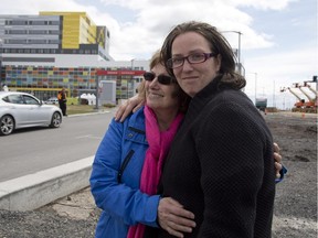 Rosaria Giancola, left, and her daughter Gabriella Giancola watched Sunday as ambulances and medicars moved patients from the Royal Victoria Hospital to the MUHC's Glen site.