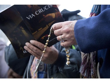 A woman says the rosary outside Notre Dame Basilica. The Way of the Cross procession, held every Good Friday in Montreal, allows the faithful to follow in the last footsteps of Christ. Friday April 3, 2015.