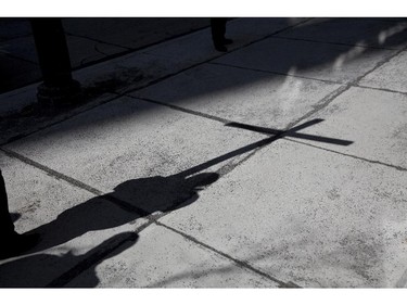 The shadow of the crucifix is cast across a sidewalk in downtown Montreal as hundreds of faithful take part in the Via Crucis (Way of the Cross), Friday April 3, 2015. The annual procession marks the final hours of Jesus' life, accompanied by prayer, meditation and song.