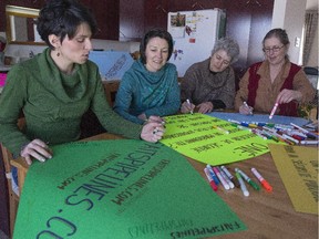In Rigaud, from left to right, Marie-Celine Campbell, Katherine Massam, Myriam Chagal and Sandra Stephenson prepare posters for the Act on Climate March on April 11 in Quebec City.
