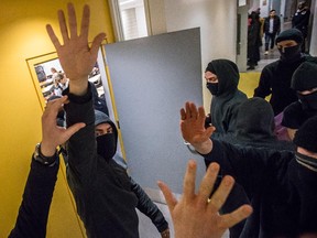 Masked student protesters participating in a student strike attempt to interrupt university French grammar class at UQAM in Montreal on Tuesday, April 7, 2015.