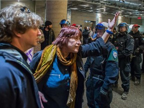 Michèle Nevert, centre, president of the teacher's union at UQAM, speaks with security agents as police form a barrier after the arrest of several protesters for disrupting classes, a violation of a court injunction, in Montreal on Wednesday, April 8, 2015. The injunction was granted to the university last week forbidding protesters from stopping students who would like to attend classes.