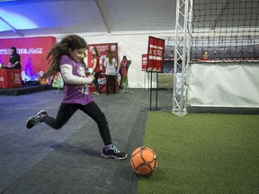 Eight-year-old Christina Papageoraiou of Dollard  takes a shot on an automated goalie as she visits the FIFA Women's World Cup tent set up at Fairview shopping centre in Pointe-Claire on Thursday, April 9, 2015.