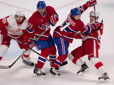 Montreal Canadiens centre David Desharnais struggles to clear Detroit Red Wings centre Riley Sheahan, right, as Montreal Canadiens right wing Devante Smith-Pelly and Detroit Red Wings defenceman Danny DeKeyser stand in front of the net during NHL action at the Bell Centre in Montreal on Thursday April 9, 2015.