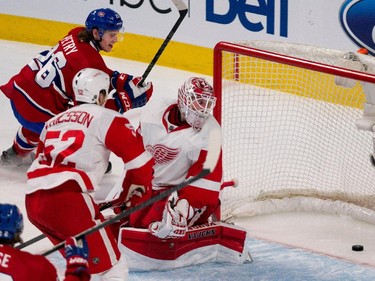Montreal Canadiens defenceman Jeff Petry, left, scores against Detroit Red Wings goalie Jimmy Howard during NHL action at the Bell Centre in Montreal on Thursday April 9, 2015. Detroit Red Wings defenceman Jonathan Ericsson looks on.
