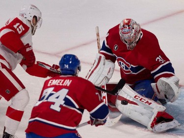 Montreal Canadiens goalie Carey Price, right, deflects a shot by Detroit Red Wings centre Riley Sheahan, left, as Montreal Canadiens defenceman Alexei Emelin looks on during NHL action at the Bell Centre in Montreal on Thursday April 9, 2015.