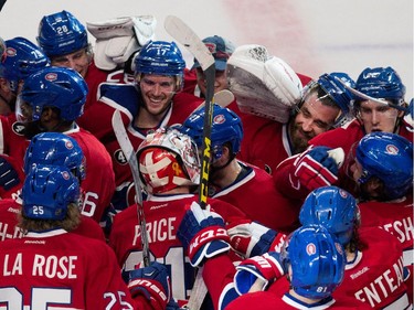Montreal Canadiens goalie Carey Price is swarmed by his teammates after beating the Detroit Red Wings in overtime at the Bell Centre in Montreal on Thursday April 9, 2015. Price set a new team record with 43 regular season wins.