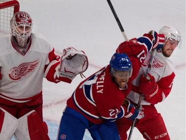 Montreal Canadiens right wing Devante Smith-Pelly, centre, struggles with Detroit Red Wings defenceman Brendan Smith as Detroit Red Wings goalie Jimmy Howard follows the play during NHL action at the Bell Centre in Montreal on Thursday April 9, 2015.