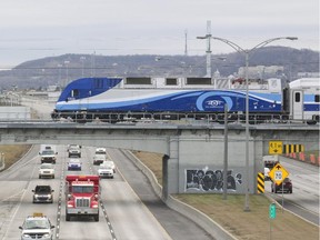 An AMT train crosses Highway 15 as it pulls out of the  Ahuntsic station on the Mascouche line.