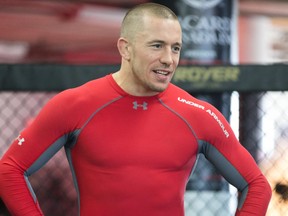 Georges St-Pierre looks on as he teaches fighting techniques to a group of prize winners during event at Tristar Gym in Montreal on February 28, 2014.