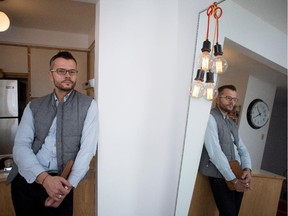 Cristophe Moreau stands between the kitchen and dining room area of his apartment.