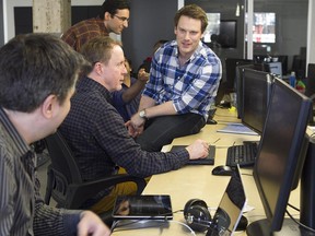SportlogiQ co-founder and CEO Craig Buntin, right, speaks with Philippe Desaulnier, far left, and Jake Chadwick in their Montreal offices on  Tuesday ,March 31, 2015. The company does sports analytics, and uses computer vision to compile intelligent data on hockey players and other athletes' skills.