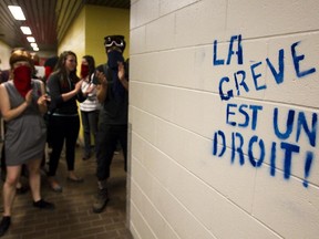 Students clap to interrupt a class after protesting students on strike stormed L'Université du Quebec à Montréal in Montreal to interrupt the few classes being held on Wednesday, May 16, 2012.