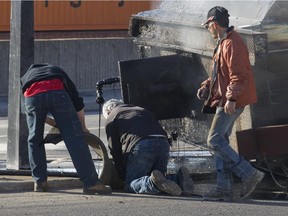 Police and transport Quebec officials inspect an overturned tar truck at the corner of de Lorimier Ave. and Notre Dame St. April 28, 2015.