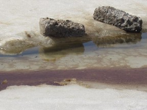 An oil-like substance is seen on the surface of the ice near the shore of Lake St-Louis close to Sources Blvd. on Monday, April 14, 2015.