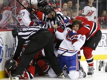 Montreal Canadiens right wing P.A. Parenteau (15) is restrained by New Jersey Devils defenseman Mark Fraser, right, during a melee in the second period of an NHL hockey game, Friday, April 3, 2015, in Newark, N.J.