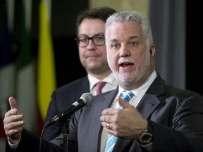 Quebec Premier Philippe Couillard speaks as he arrives at a summit on climate change, as Quebec Environment Minister David Heurtel looks on, Tuesday, April 14, 2015 in Quebec City.