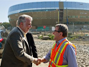 Quebec Premier Philippe Couillard shakes hands with Quebec City Mayor Régis Labeaume, right,as he arrives to visit the construction site for the new arena in Quebec City, Friday, September 26, 2014 .