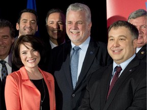 Quebec Premier Philippe Couillard, flanked by byelection candidates Véronyque Tremblay, left, for Chauveau, and Sébastien Proulx, for Jean-Talon.