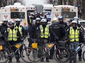 Police surround a group of demonstrators during a protest against government austerity measures, Thursday, April 9, 2015 in Montreal