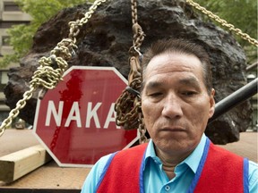 Chief Real McKenzie of the Innu Matimekush-Lac John band stands in front of a giant stone at a protest at the Rio Tinto building Wednesday, October 1, 2014 in Montreal.