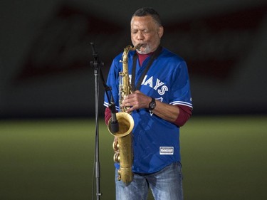Russel Martin Sr., father of Toronto Blue Jays catcher Russell Martin, plays the national anthems on his saxophone during a pre-game ceremony as the Toronto Blue Jays face the Cincinnati Reds in  MLB exhibition play Friday, April 3, 2015, in Montreal.