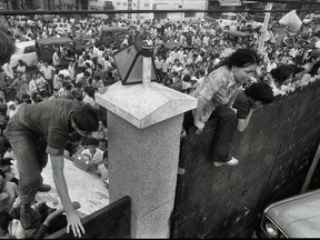 In this April 29, 1975 file photo, South Vietnamese civilians scale the 14-foot wall of the U.S. embassy in Saigon, trying to reach evacuation helicopters as the last Americans departed from Vietnam.