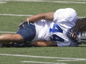 Montreal Alouettes defensive back Andrew Lue writhes in pain from a cramp during the first day of the team's training camp in 2014.