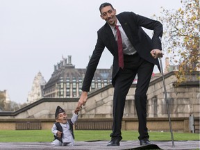TOPSHOTS Chandra Bahadur Dangi, from Nepal, (L) the shortest adult to have ever been verified by Guinness World Records, poses for pictures with the world's tallest man Sultan Kosen from Turkey, during a photocall in London on November 13, 2014, to mark Guinness World Records Day. Chandra Dangi, measures a tiny 21.5in (0.54m)  the same height as six stacked cans of beans. Sultan Kosen measures 8 ft 3in (2.51m).
