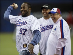 Former Montreal Expos Vladimir Guerrero throws a ceremonial pitch next to Montreal mayor Denis Coderre and former teammate Orlando Cabrerra during a pre-game ceremony as the Toronto Blue Jays face the Cincinnati Reds in MLB exhibition play Friday, April 3, 2015 in Montreal.
Coderre says he has asked the commissioner of Major League Baseball to consider holding three or four regular-season games in the city in 2016.