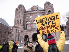 A demonstrator holds up a sign while gathering with others in front of Queen's Park to protest against Ontario's new sex education curriculum in Toronto on Tuesday, February 24, 2015. A group of Ontario parents is threatening to pull their kids out of school this week, in protest of the province's new sex-education curriculum.
