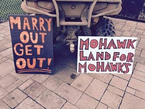 File photo of signs placed at a Kahnawake home reading: "Marry out get out" and "Mohawk land for Mohawks."