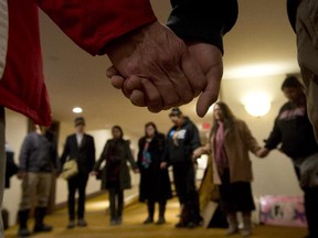 A group of protesters hold hands during a prayer outside the National Roundtable on Missing and Murdered Indigenous Women and Girls Friday, February 27, 2015 in Ottawa.
