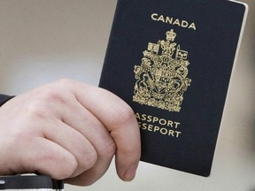 A passenger holds his Canadian passport before boarding a flight in Ottawa on Jan 23, 2007.