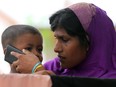 A Rohingya migrant woman weeps after she talks with her relative on mobile phone at a temporary shelter in Indonesia, May 25, 2015.