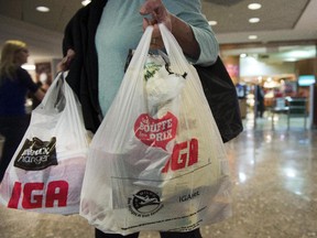A woman leaves a grocery store Friday, May 15, 2015 in Montreal. The city has begun consultations on wether to ban the use of plastic bags in grocery stores.THE CANADIAN PRESS/Ryan Remiorz
