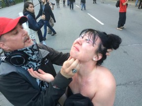 A woman reacts after getting tear gas in her eyes as people take part in the the annual anti-capitalist May Day protest in Montreal on Friday May 1, 2015.