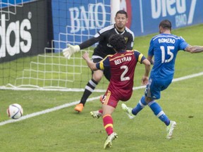 Montreal Impact's Andres Romero, right, scores on Real Salt Lake goalkeeper Nick Rimando as Salt Lake's Tony Beltran defends during first half MLS soccer action in Montreal, Saturday, May 16, 2015.