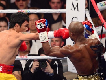 Floyd Mayweather Jr. (R) defends against Manny Pacquiao (L) during their welterweight unification bout on May 2, 2015 at the MGM Grand Garden Arena in Las Vegas, Nevada.