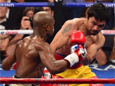 Manny Pacquiao (R) defends against Floyd Mayweather Jr. (L) during their welterweight unification bout on May 2, 2015 at the MGM Grand Garden Arena in Las Vegas, Nevada.