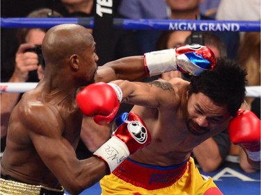 Floyd Mayweather Jr., and Manny Pacquiao (R) fight in a welterweight unification bout on May 2, 2015 at the MGM Grand Garden Arena in Las Vegas, Nevada.