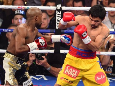 Floyd Mayweather Jr., and Manny Pacquiao (R) fight in a welterweight unification bout on May 2, 2015 at the MGM Grand Garden Arena in Las Vegas, Nevada.
