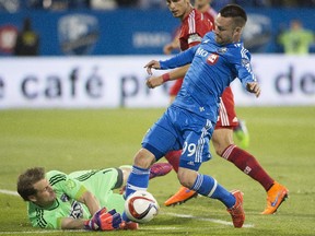 Impact striker Jack McInerney moves in on FC Dallas goalkeeper Dan Kennedy during MLS game at Saputo Stadium on May 23, 2015.