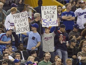 Fans hold up signs as the Toronto Blue Jays face the Cincinnati Reds in Grapefruit League play on April 3, 2015 at Olympic Stadium.