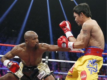 Floyd Mayweather Jr., left, connects with a left to the body of Manny Pacquiao, from the Philippines, during their welterweight title fight on Saturday, May 2, 2015 in Las Vegas.