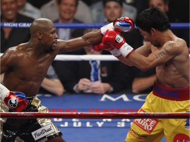 Manny Pacquiao, from the Philippines, right, blocks a shot by Floyd Mayweather Jr., during their welterweight title fight on Saturday, May 2, 2015 in Las Vegas.