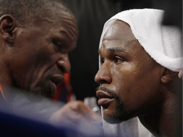 Floyd Mayweather Jr., right, listens to his father, head trainer Floyd Mayweather Sr., between rounds during his welterweight title fight against Manny Pacquiao, from the Philippines, on Saturday, May 2, 2015 in Las Vegas.