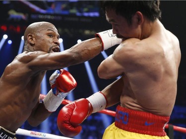 Floyd Mayweather Jr., left, punches Manny Pacquiao, from the Philippines, during their welterweight title fight on Saturday, May 2, 2015 in Las Vegas.