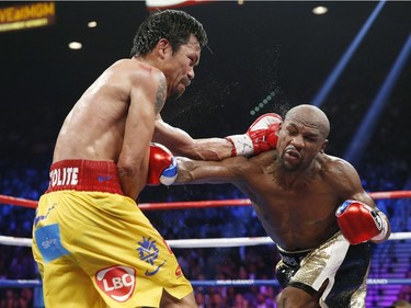 Manny Pacquiao, from the Philippines, left, trades punches with Floyd Mayweather Jr., during their welterweight title fight on Saturday, May 2, 2015 in Las Vegas.