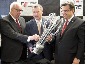 Promoter François Dumontier, centre, holds up this year's trophy as Senator Jacques Demers, left, and Mayor Denis Coderre, look on at a news conference to launch the Formula One Canadian Grand Prix weelemd on May 15, 2015 in Montreal. The Grand Prix will be held at Circuit Gilles Villeneuve on June 5-6-7, 2015.